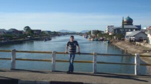 man standing on a bridge over a river