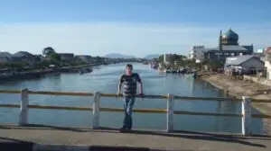 man standing on a bridge over a river