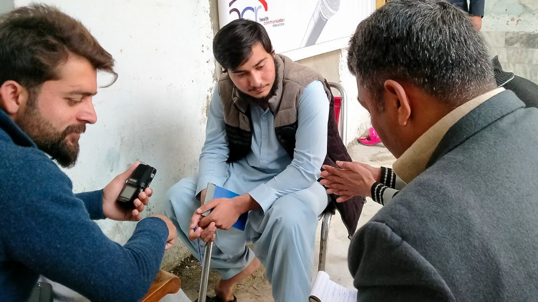 Several participants sit around and discuss community topics at a media workshop in Pakistan.