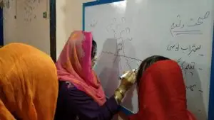 3 women writing on white board