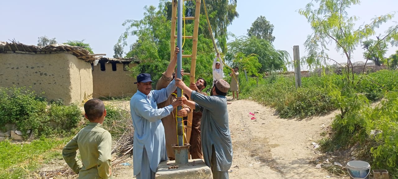 Men feeding plastic lining into new borehole