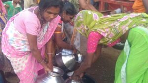 Adivasi women filling water pitchers