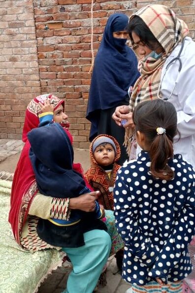 Women and children talking in brick courtyard