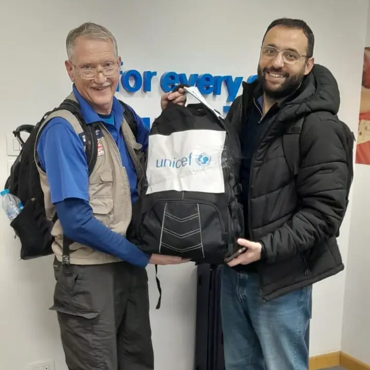 2 men holding a backpack radio station for Gaza