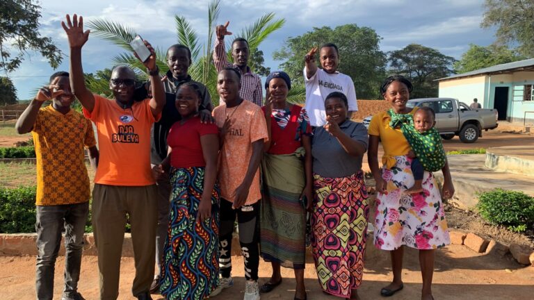 A group of people waving and smiling