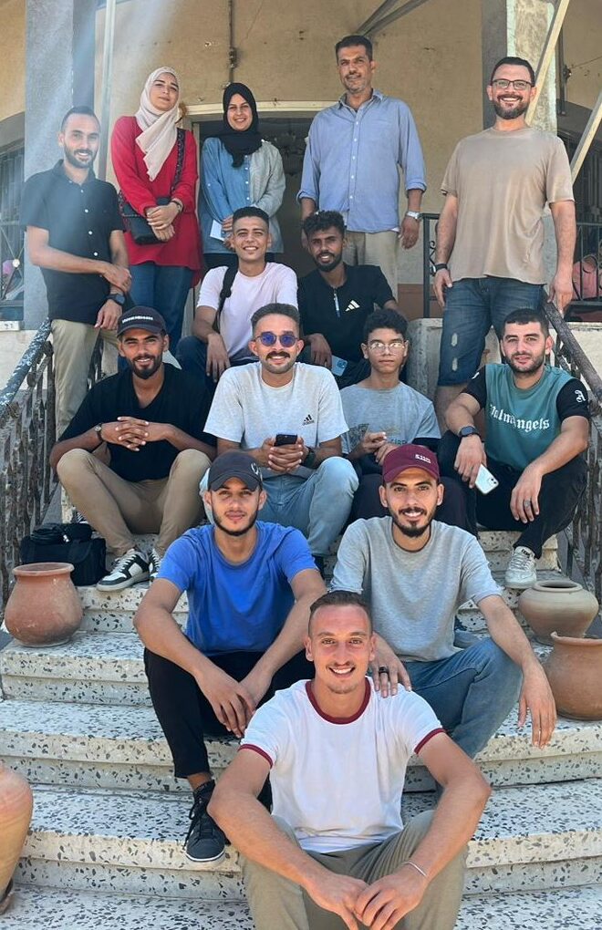 Team portrait A group of people facing the camera, seated on an outdoor staircase