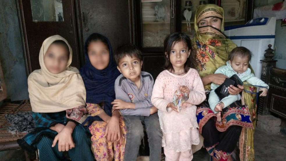 Pakistani children sitting with their mother